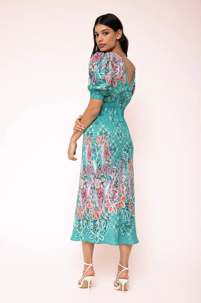 
                  
                    Melody Cut-Out Midi Dress Introducing the Melody Cut Out Midi Dress by Kachel—a striking showstopper featuring voluminous sleeves and intricate front and back cut-out details. Its subtle border paisley print is a wardrobe essential, effortlessly elevating your style.
                  
                